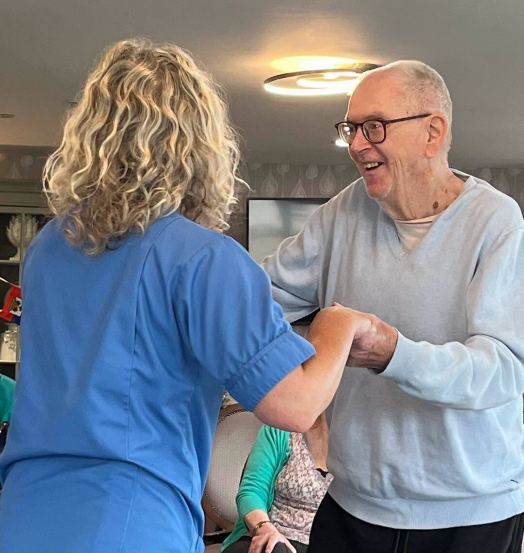 care home resident dancing with staff member