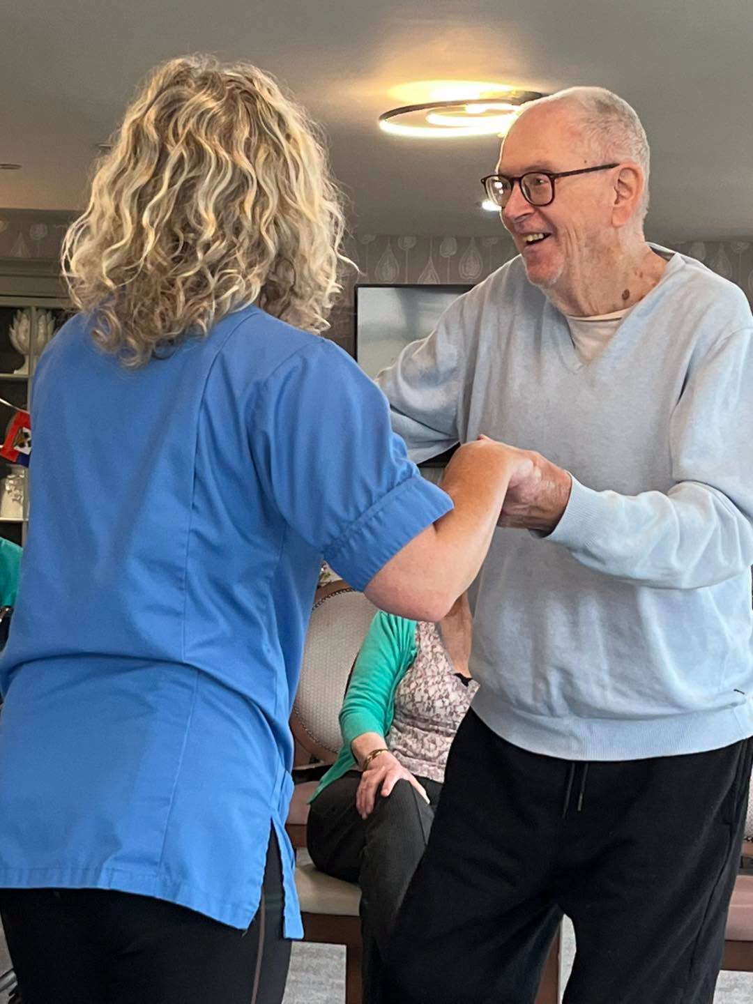 care home resident dancing with staff member