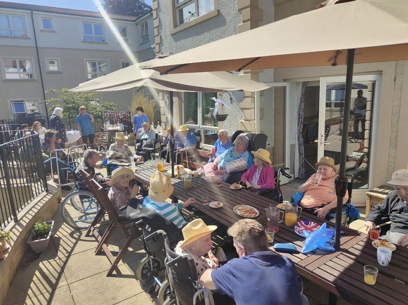 residents sitting around tables on the outdoor patio at haddington care home