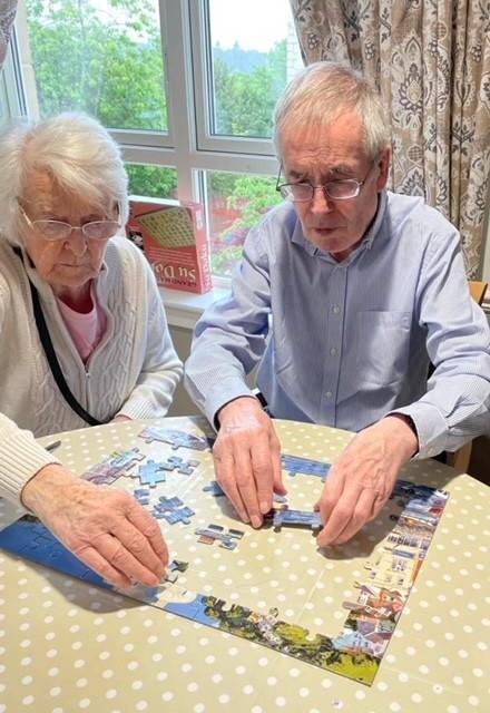 residents playing puzzle games on table