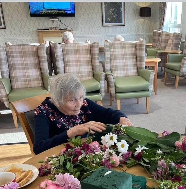 Resident arranging flowers for bouquet