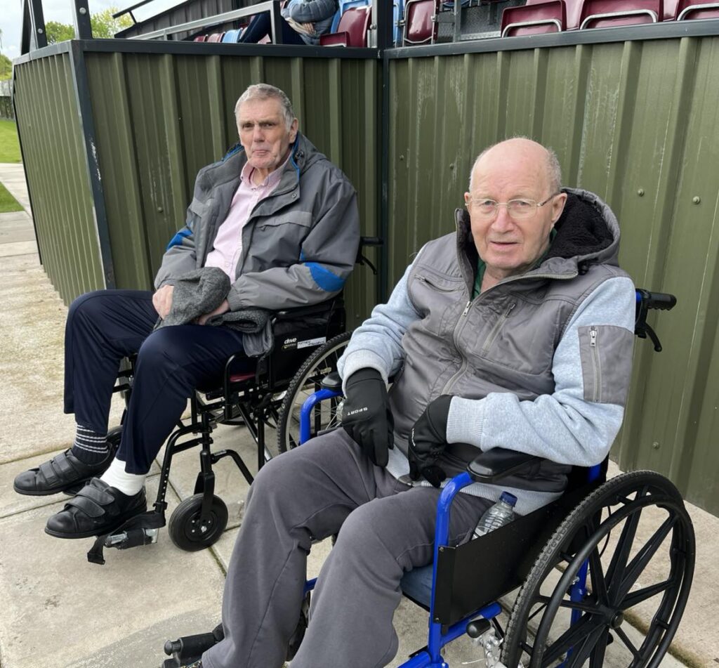 two older men sat down in wheelchairs