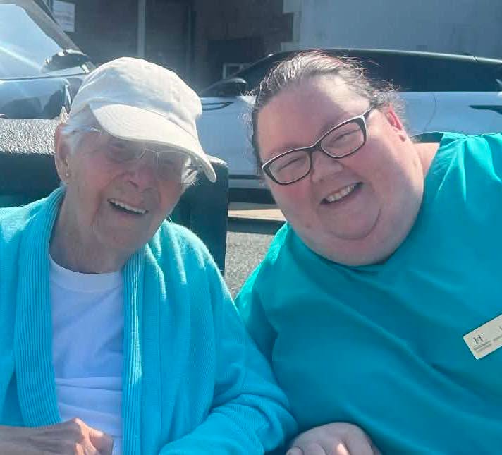 resident and staff member smiling at the beach
